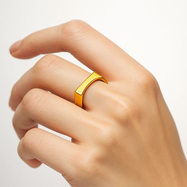 Woman's hand wearing a modern gold bar signet ring on ring finger against white background