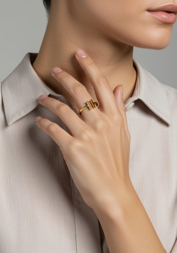 Close-up of a woman wearing a pave split gold bar ring with a beige shirt
